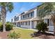 Charming townhome exterior with well-maintained landscaping, a blue sky and palm trees at 1890 Colony Dr. # 17T, Surfside Beach, SC 29575