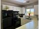 Bright kitchen featuring a black refrigerator and oven, white cabinets, and a window at 1890 Colony Dr. # 17T, Surfside Beach, SC 29575