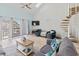 Bright living room with a spiral staircase, balcony access, and comfortable seating arrangement at 1890 Colony Dr. # 17T, Surfside Beach, SC 29575