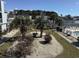 Scenic view of the community pool area, surrounded by lush landscaping and cozy sunbathing chairs at 1890 Colony Dr. # 17T, Surfside Beach, SC 29575