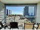 Charming balcony featuring seating and an ocean view, nestled between two hotels on a sunny day at 2000 S Ocean Blvd. # V401 A&B, Myrtle Beach, SC 29577