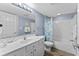 Well-lit bathroom with a vanity, toilet, and shower-tub combo and wood look floors at 2007 S Ocean Blvd. # 2006, Myrtle Beach, SC 29577