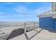 Spacious deck with metal railings overlooking a beautiful, sandy beach and ocean at 2201 S Waccamaw Dr., Murrells Inlet, SC 29576