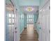 Inviting entryway featuring wood floors, glass paneled doors, and open staircase with light turquoise walls at 2201 S Waccamaw Dr., Murrells Inlet, SC 29576