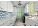 Well-lit laundry room with custom cabinets, floral backsplash, and a laundry machine at 2201 S Waccamaw Dr., Murrells Inlet, SC 29576