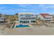 Beautiful blue beach house with a pool, spacious deck, white picket fence, and sandy beach access at 2201 S Waccamaw Dr., Murrells Inlet, SC 29576