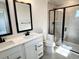 Well-lit bathroom with double vanity, quartz countertop, and glass-enclosed walk-in shower at 2317 Hazel Way, Longs, SC 29568