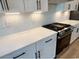 Modern kitchen features white cabinets, herringbone backsplash, and stainless steel gas range at 2317 Hazel Way, Longs, SC 29568