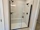 Modern walk-in shower with glass door, a built-in bench, and white marble-style tile at 2317 Hazel Way, Longs, SC 29568