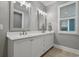 Well-lit bathroom features double vanity sinks, storage cabinets, and shuttered windows at 2323 Tidewatch Way, North Myrtle Beach, SC 29582