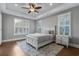 Comfortable bedroom featuring hardwood floors, tray ceiling, plantation shutters and natural light at 2323 Tidewatch Way, North Myrtle Beach, SC 29582