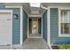Covered home entrance featuring wood-look siding, white trim and a glass-paneled front door at 2323 Tidewatch Way, North Myrtle Beach, SC 29582