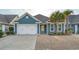 Charming single Gathering home with blue siding, a two-car garage and well-maintained landscaping at 2323 Tidewatch Way, North Myrtle Beach, SC 29582