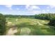 An aerial view of a lush golf course featuring undulating greens, mature trees, and meticulously manicured fairways at 2323 Tidewatch Way, North Myrtle Beach, SC 29582
