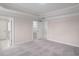 A bedroom with carpet, tray ceilings, and multiple doorways at 308 Starlit Way, Myrtle Beach, SC 29579