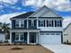 Charming two-story home with a blue and white exterior, black shutters, and a pristine two-car garage at 308 Starlit Way, Myrtle Beach, SC 29579