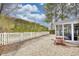 Spacious backyard featuring a gravel area, white picket fence, mature trees, and a cozy patio table set at 3736 Brookhill Dr., Myrtle Beach, SC 29588