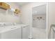 Bright laundry room featuring a washer, dryer, shelving, and additional storage, with easy access to the walk in closet at 4043 Bucolic Loop, Myrtle Beach, SC 29588