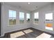 Sunlit living room boasts many large windows and a glass door that fills the space with natural light and highlights the wood floors at 4043 Bucolic Loop, Myrtle Beach, SC 29588
