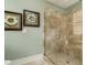 Walk-in shower with tile surround, glass door, bench, and decorative wall art at 405 Banyan Place, North Myrtle Beach, SC 29582
