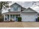 Charming two-story home with a well-manicured lawn, attached two-car garage, and a welcoming front porch at 405 Banyan Place, North Myrtle Beach, SC 29582