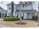 View of the home's back exterior showing the screen porch, neutral siding and mature shade trees at 405 Banyan Place, North Myrtle Beach, SC 29582