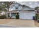 Charming two-story home with a well-manicured lawn, attached two-car garage, and a welcoming front porch at 405 Banyan Place, North Myrtle Beach, SC 29582
