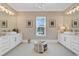 A bright bathroom features double sinks and vanities, a central window for natural light, and tile flooring at 410 44Th Ave. N, Myrtle Beach, SC 29577