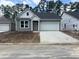 Charming gray one-story home with a two-car garage and contemporary architectural details at 444 Sun Colony Blvd., Longs, SC 29568