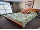 Neutral bedroom featuring a wooden bed frame, a large window, and leafy green patterned bedding at 4633 Lightkeepers Way # 5K, Little River, SC 29566
