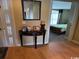 Hallway view showcasing wood flooring, a decorative table, and a glimpse into a bedroom at 4633 Lightkeepers Way # 5K, Little River, SC 29566