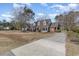 A two-story brick and white home featuring a long concrete driveway at 4721 National Dr., Myrtle Beach, SC 29579