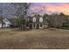 Charming two-story brick and white home with a welcoming front porch and mature landscaping at dusk at 4721 National Dr., Myrtle Beach, SC 29579