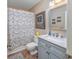 Updated bathroom with gray vanity, marble countertop, and shower with patterned curtain at 473 White River Dr. # C, Myrtle Beach, SC 29579