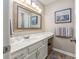 Well-lit bathroom featuring a large framed mirror, white vanity, and wood-look flooring at 473 White River Dr. # C, Myrtle Beach, SC 29579