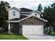 Charming two-story home featuring stone accents, a two-car garage, and inviting curb appeal with landscaping at 5005 Riverton Ct, Myrtle Beach, SC 29579