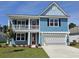 Charming two-story blue home with a spacious two-car garage and landscaped front yard under a clear blue sky at 518 Haven View Way, Murrells Inlet, SC 29576