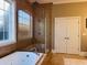 Bathroom featuring a glass-enclosed shower, soaking tub, tiled walls, and window providing natural light at 5220 Mount Pleasant Dr., Myrtle Beach, SC 29579