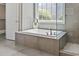 Bright bathroom with modern tub, tile accents, and a clear glass shower, offering a luxurious and relaxing experience at 5220 Mount Pleasant Dr., Myrtle Beach, SC 29579