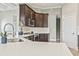 Close-up of a contemporary kitchen showcasing quartz countertops, modern appliances, and stylish dark wood cabinetry at 5220 Mount Pleasant Dr., Myrtle Beach, SC 29579
