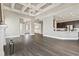Expansive living room boasting a coffered ceiling, wood floors, and seamless transition to the modern kitchen at 5220 Mount Pleasant Dr., Myrtle Beach, SC 29579