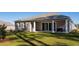 A view of the back of the house from the yard, showing a covered patio with a table and chairs at 585 Haven View Way, Murrells Inlet, SC 29576