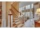 Elegant staircase leading to a light-filled living room with a soaring ceiling and large windows at 707 Compass Pointe Dr, North Myrtle Beach, SC 29582