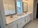 Bathroom featuring dual sink vanities, white cabinets, framed mirrors, and white countertops at 9021 Aria Way, Longs, SC 29568