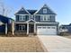 Beautiful two-story home features a symmetrical design, blue siding, and a spacious two-car garage at 9021 Aria Way, Longs, SC 29568