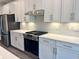 Gourmet kitchen with stainless appliances, sleek range hood, white cabinets, and quartz countertops at 9021 Aria Way, Longs, SC 29568