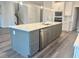Kitchen island with stainless steel appliances, a quartz countertop, and gray cabinetry at 9021 Aria Way, Longs, SC 29568