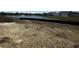 An empty dirt lot for sale with a pond in the backyard with the community in the background at 903 Agostino Dr., Myrtle Beach, SC 29579