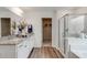 Bathroom featuring double sinks, white cabinetry, granite countertops, glass-enclosed shower, and walk-in closet at 903 Agostino Dr., Myrtle Beach, SC 29579