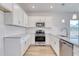 Bright kitchen featuring white cabinets, granite countertops, stainless steel appliances, and wood-look flooring at 915 Agostino Dr., Myrtle Beach, SC 29579